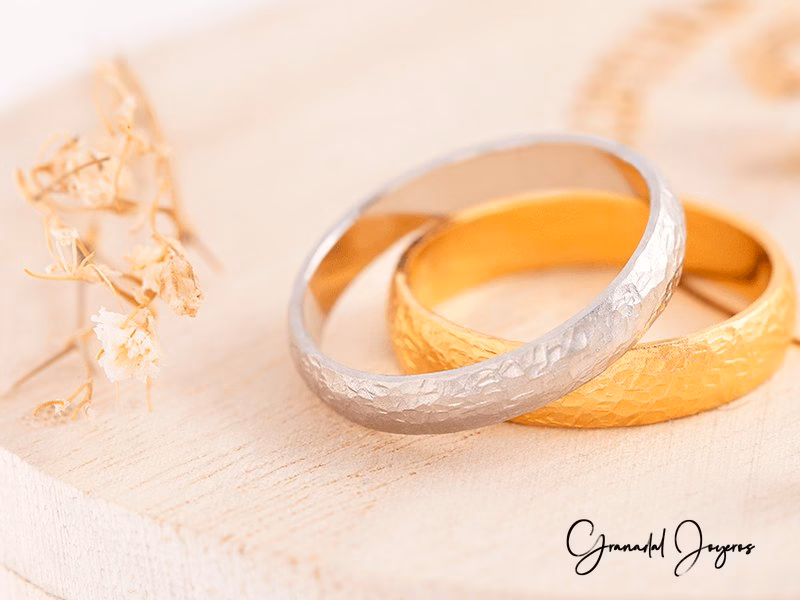 Alianzas de boda en oro blanco y oro amarillo con acabado martel&eacute;